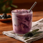 A layered Starbucks Midnight Drink copycat in a clear glass with blackberries on marble.
