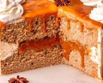 Delicious slice of homemade spice cake topped with cream and spices.