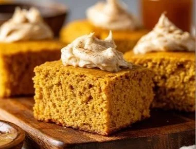 Delicious Pumpkin Cornbread topped with Cinnamon Honey Butter on a wooden table.